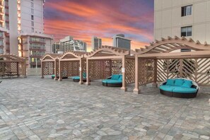 A rooftop terrace with stone flooring, outdoor seating, and a cityscape view. - *NEW* 30-Night Waikiki Stay with Mountain and Canal Views (Honolulu)