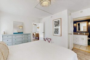 Ein Schlafzimmer mit Bett, Schminktisch und einem durchgegangenen Tür angedeuteten Badezimmer.