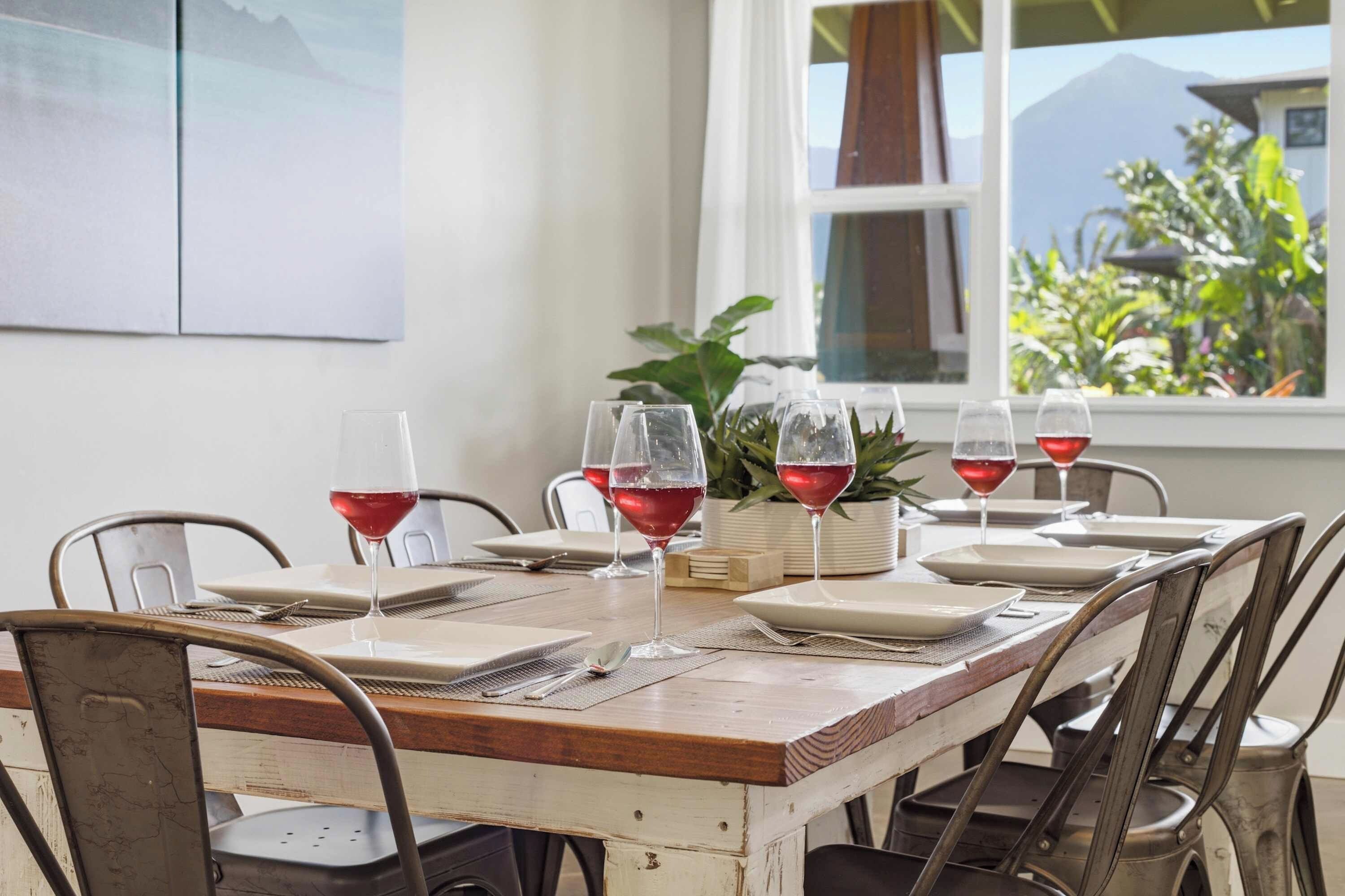 A dining table set for six with wine glasses, plates, and cutlery.