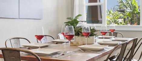 A dining table set for six with wine glasses, plates, and cutlery.