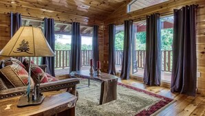 Un interior de madera con sofá, mesa y cortinas.