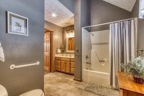 A bathroom with a bathtub, shower, toilet, and vanity. - Foxes Den (Pigeon Forge)