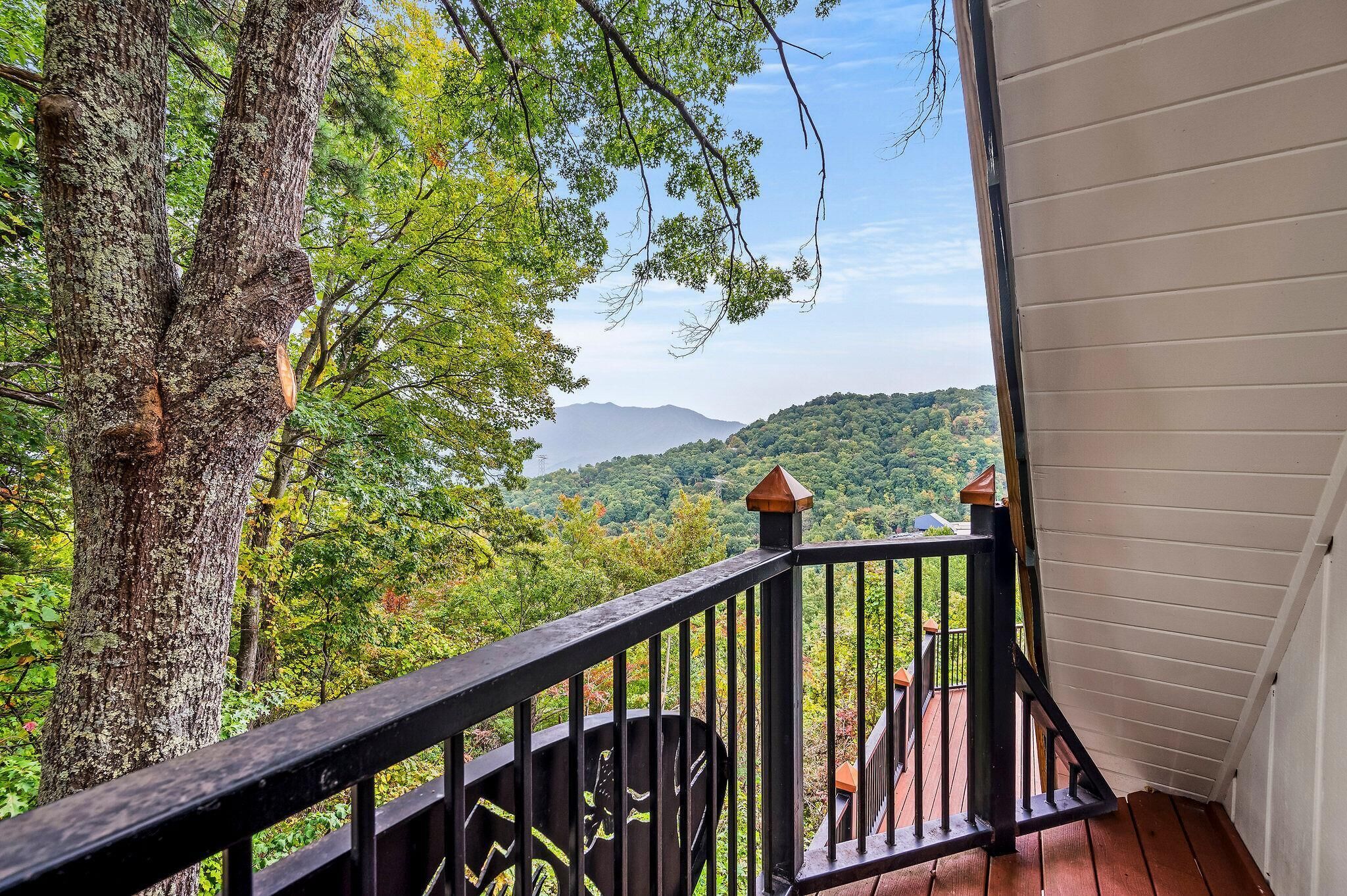 A balcony with a view of a forested mountain range.