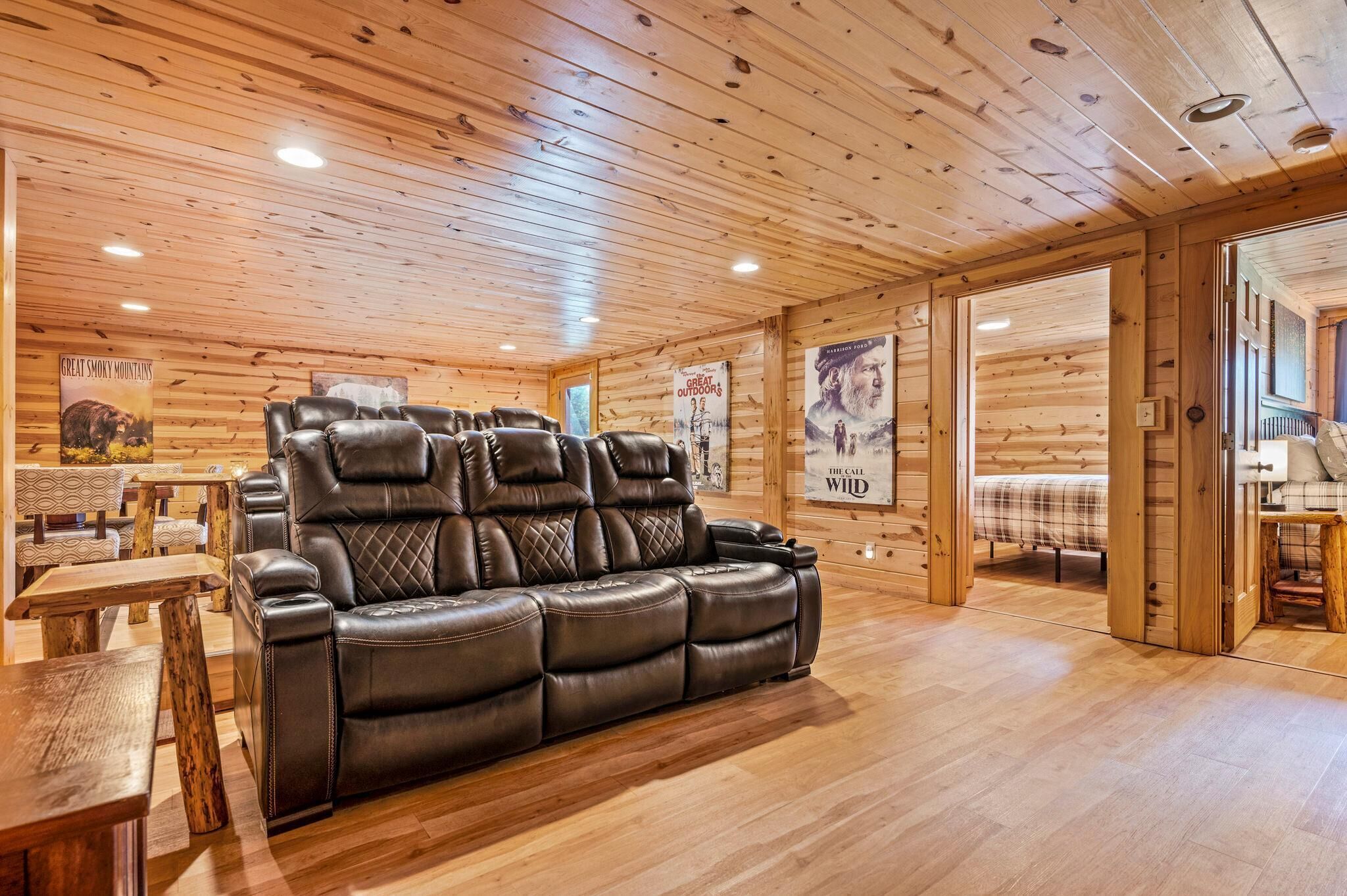 A wooden interior with a leather sofa, wooden tables, and posters on the walls.