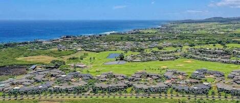Un resort costero con varias edificaciones, zonas verdes y un campo de golf.