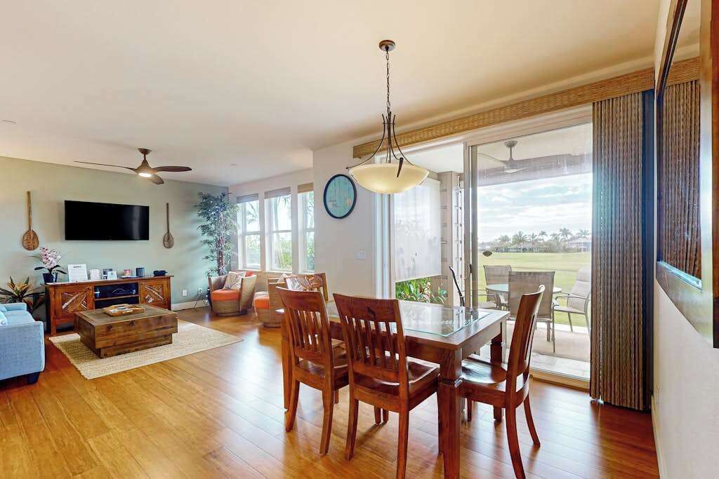 Amplia sala de estar con mesa de comedor, sillas, televisor y un gran ventanal con vistas al exterior.