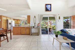 Une cuisine moderne avec des meubles en bois, un réfrigérateur et un coin repas comprenant une table et des chaises.
