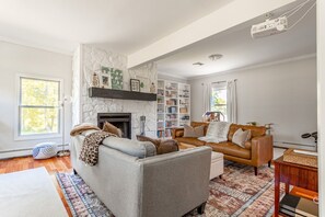 A living room with a fireplace, a bookshelf, a sofa, and a coffee table.