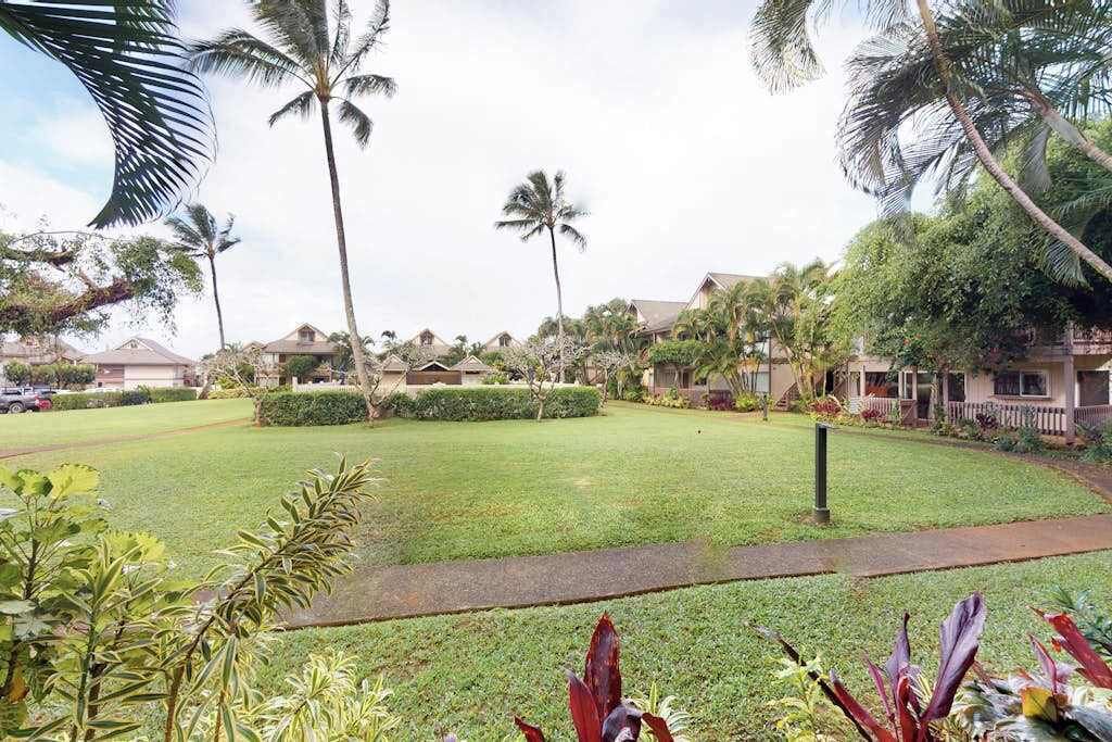Un barrio residencial con casas, palmeras y un césped cuidado.