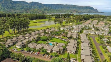 A residential area with houses, a golf course, and a body of water.