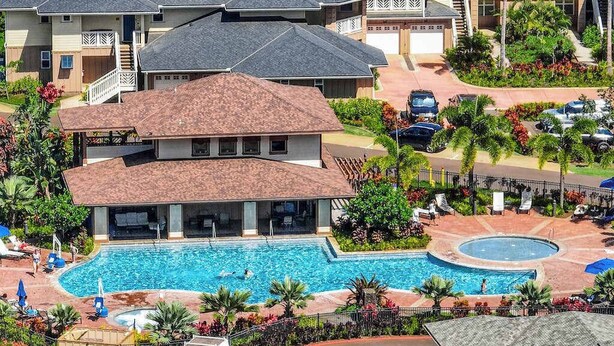 Un edifici residencial amb piscina, diversos balcons i un jardí ben cuidat.