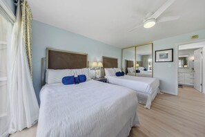 A hotel room with two beds, a ceiling fan, and a large mirror. - *NEW* Fall $pecial Beachside Kapaa Condo with Three Pools and Hot Tubs (Kapaa)
