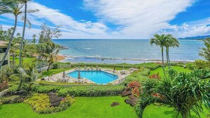 A pool surrounded by tropical landscaping, overlooking a beach and ocean. - *New* Oceanfront Wailua Escape Near Lae Nani Beach (Kapaa)