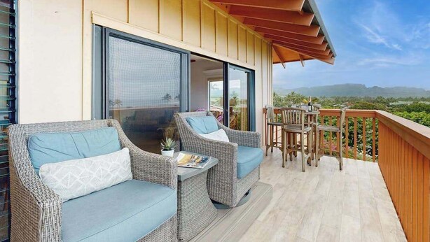 Ein Balkon mit Korbmöbeln und Blick auf die Landschaft.
