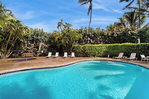 A swimming pool with lounge chairs, surrounded by tropical vegetation. - *New* Ground-Floor Kapaa 1BR Steps from the Beach (Kapaa)