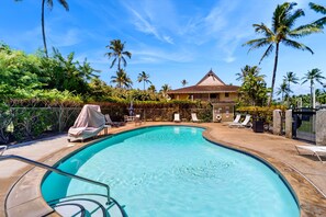 A swimming pool with lounge chairs, palm trees, and a building in the background. - Ground-Floor Kapaa Retreat 250 Yards from the Beach (Kapaa)
