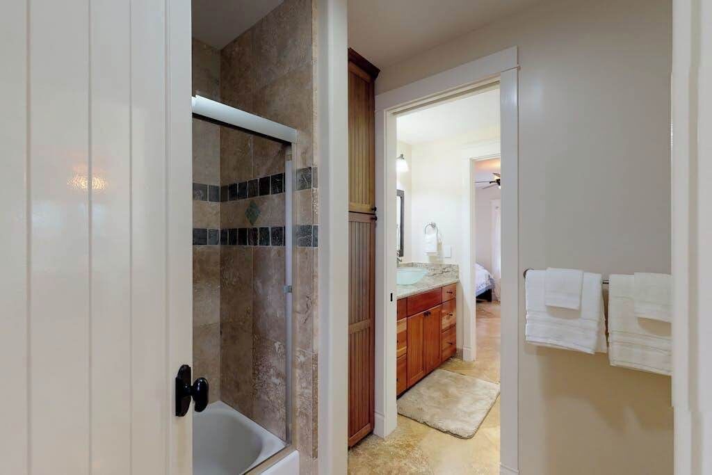 A bathroom with a shower, a toilet, and a sink.