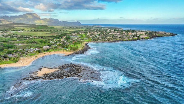 Une ville côtière dotée d’une plage, d’un littoral rocheux et bordée de montagnes.