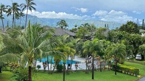 Ein Resort mit Schwimmbad, Palmen und Blick auf Berge.