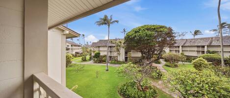 A hotel courtyard with a central lawn, surrounding buildings, and a clear sky.