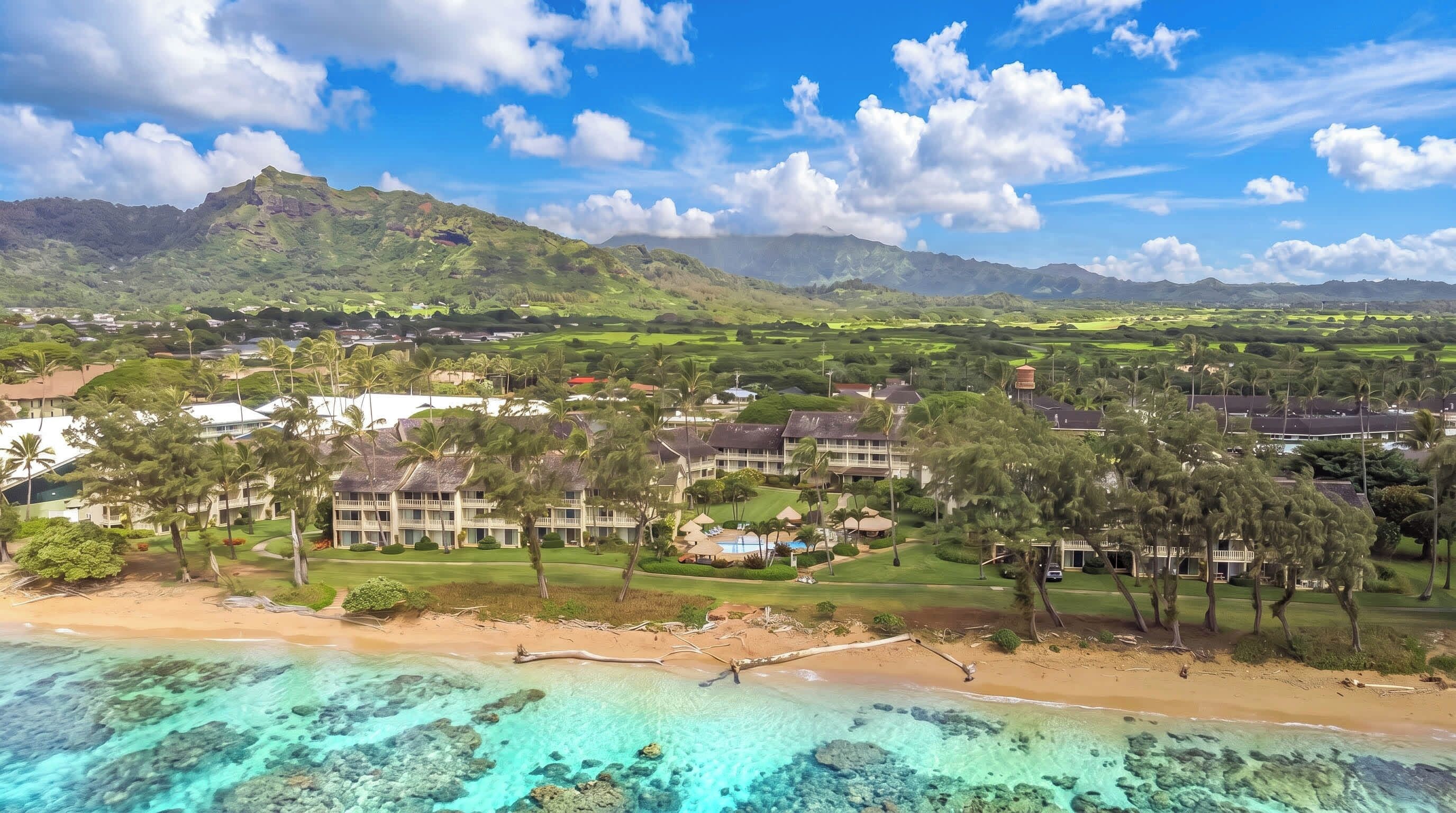 A resort with multiple buildings, a beach, and clear turquoise waters.