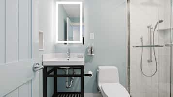A modern bathroom with a white sink, a toilet, and a shower area.