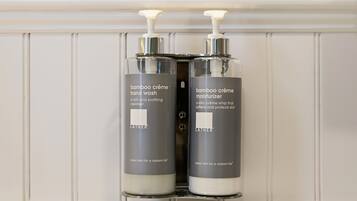Zwei Flaschen Lather Bamboo Creme Handseife und Feuchtigkeitscreme auf einem weißen Regal.