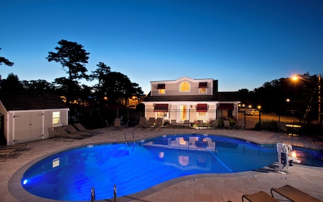 A swimming pool with a house in the background.