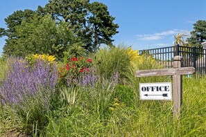 A signpost with 'OFFICE' written on it, surrounded by various plants and trees. - Wilder Inn South Wellfleet, Outset Collection by Hilton (Wellfleet)
