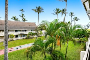 A hotel with a pool, palm trees, and a building with a tiled roof. - NEW Fall $ale Renovated Kapaa Escape Near the Beach and Pool (Kapaa)