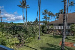 A hotel with a tropical garden, palm trees, and a building with a tiled roof. - NEW Fall $ale Renovated Kapaa Escape Near the Beach and Pool (Kapaa)