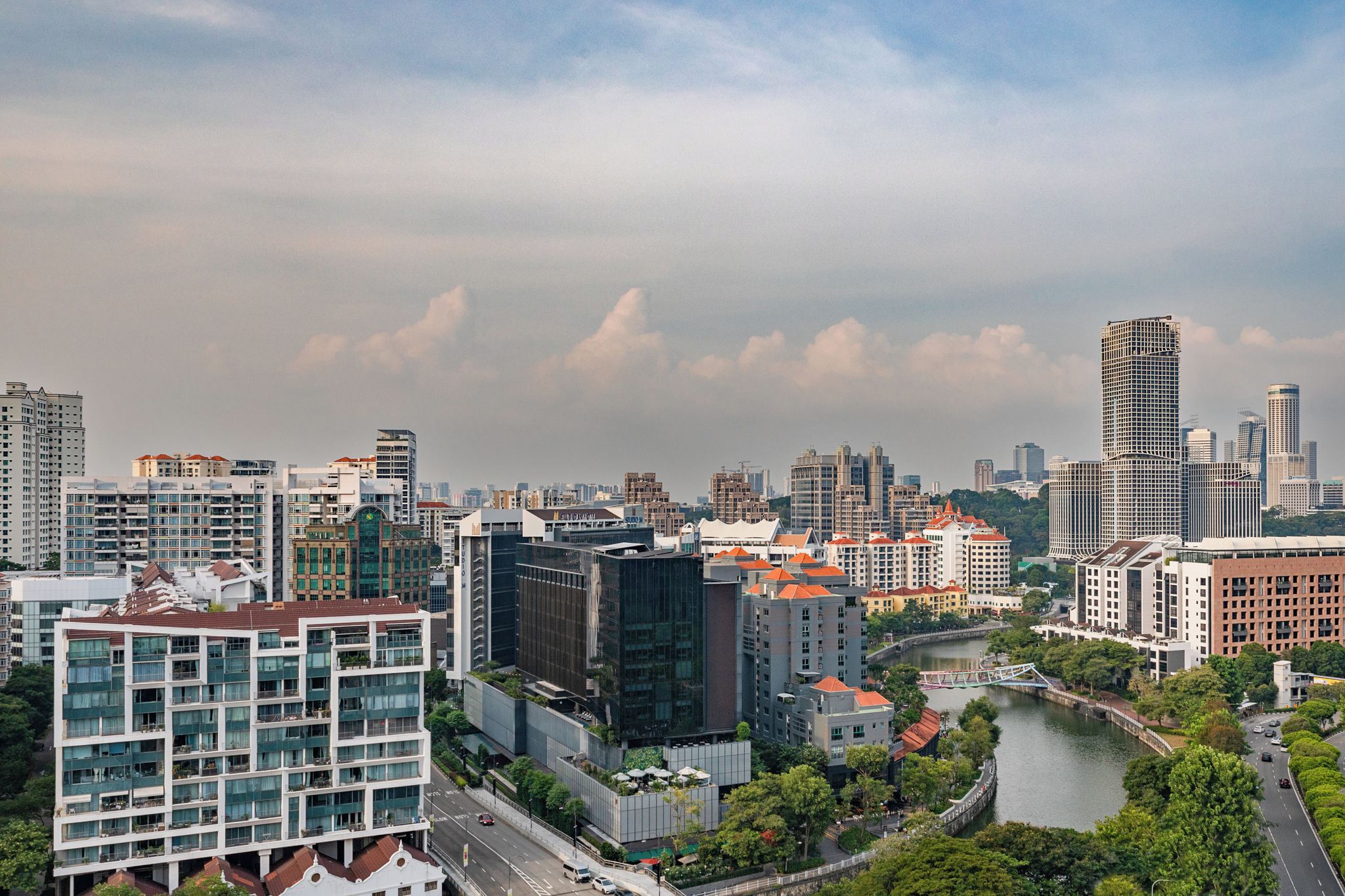 A cityscape with modern buildings, a river, and a bridge.