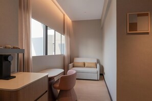 A hotel room with a desk, chair, and a sofa. - DoubleTree By Hilton Singapore Robertson Quay (Singapore)