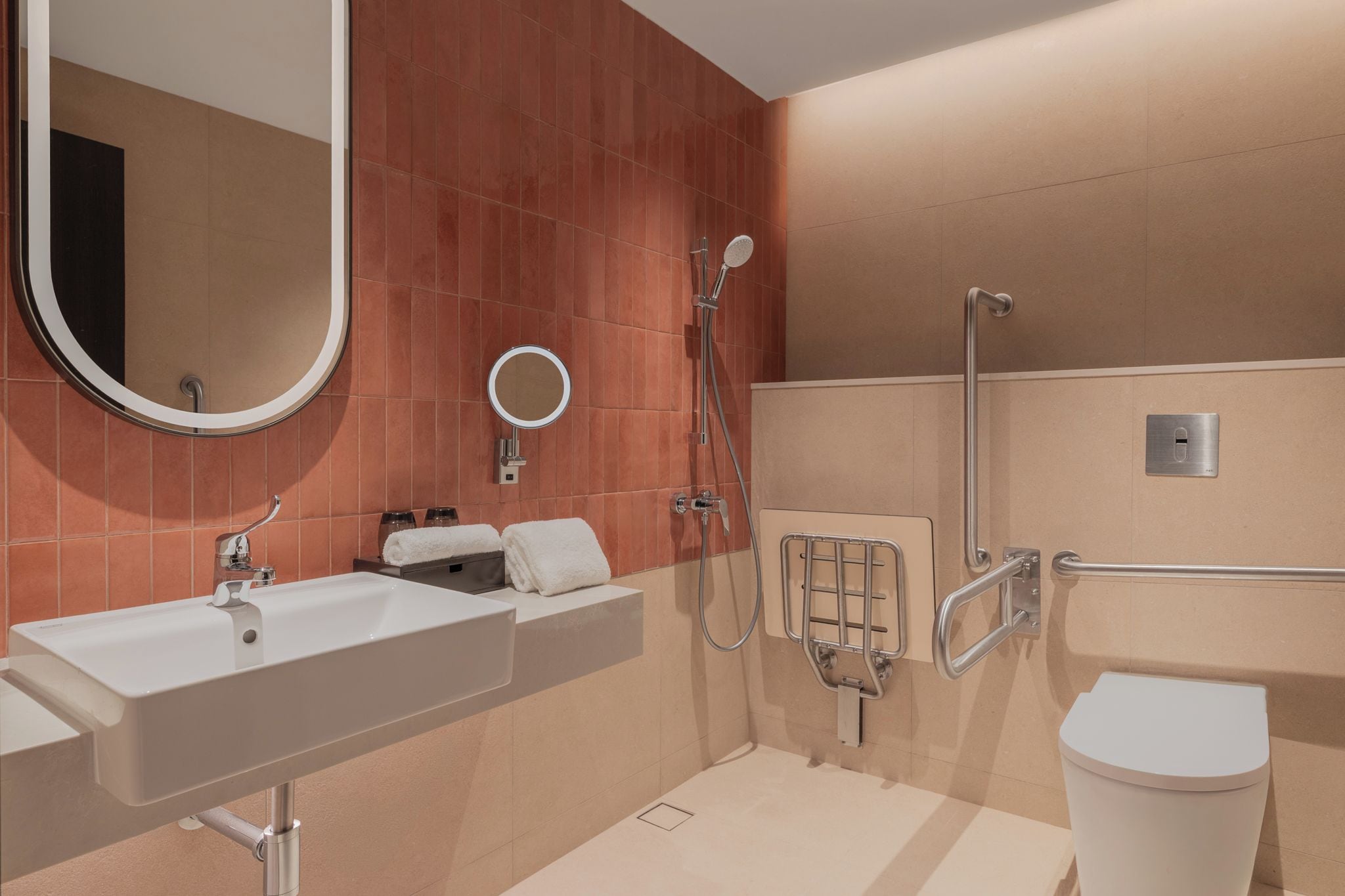 A modern bathroom with a large sink, a mirror, a shower, and a toilet.
