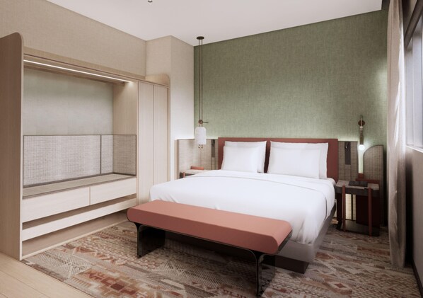 Habitación de hotel con una cama grande, un banco, una zona de estar y un televisor montado en la pared.
