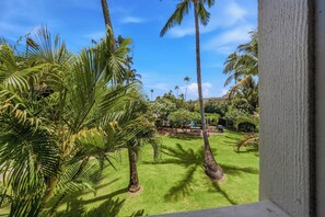 A lush garden with palm trees and a clear blue sky. - *NEW* Fall Sale Remodeled Kapaa 1BR with Lanai and Beach Access (Kapaa)
