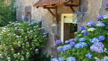 Un bâtiment rustique avec une porte en bois et un petit porche.