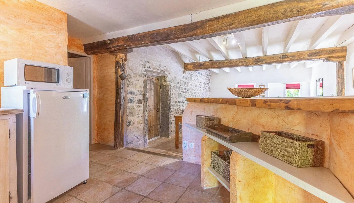 Eine Küche mit Kühlschrank, Mikrowelle und einer Holzausstattung mit Körben.