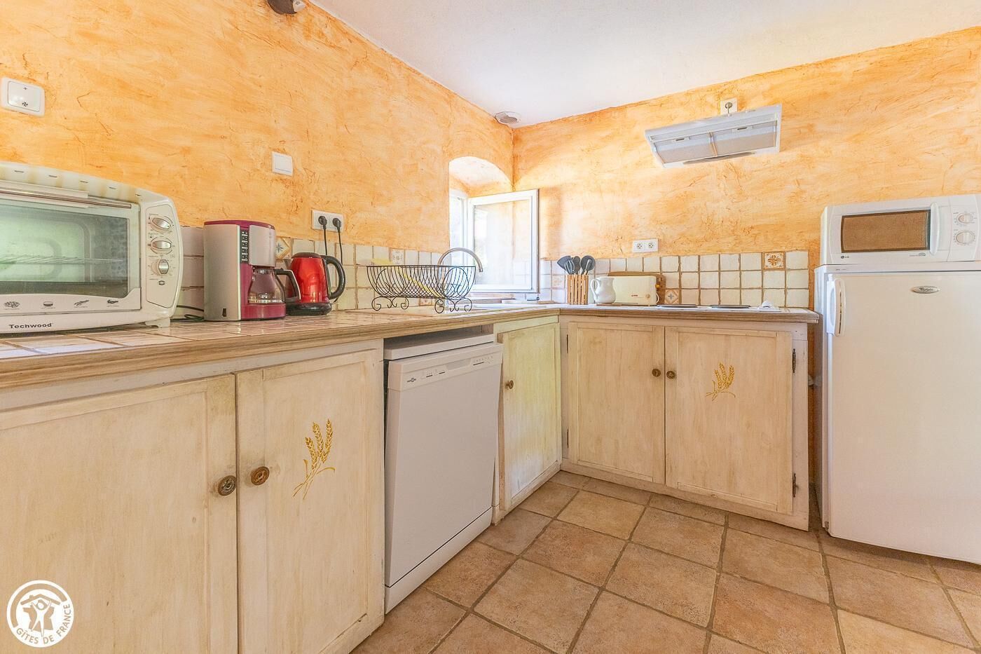 A kitchen with a microwave, coffee maker, and dishwasher.