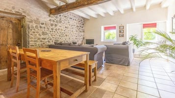 Un intérieur rustique avec un mur en pierre, des meubles en bois et un sol carrelé.