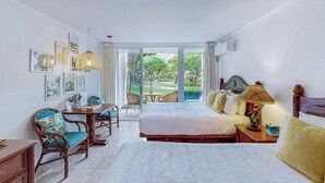 Ein Hotelzimmer mit Bett, Schreibtisch, Stühlen und Blick ins Freie.
