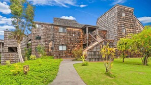 A modern building with a wooden facade, a central staircase, and a well-maintained garden. - Oceanfront Sealodge Condo at Princeville w/ Kitchen, Essentials, Beach, Shopping (Princeville)