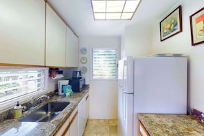 A compact kitchen with a sink, countertop, and a refrigerator. - New Ground-Floor Kauaʻi Studio With Ocean View and Lanai (Kapaa)