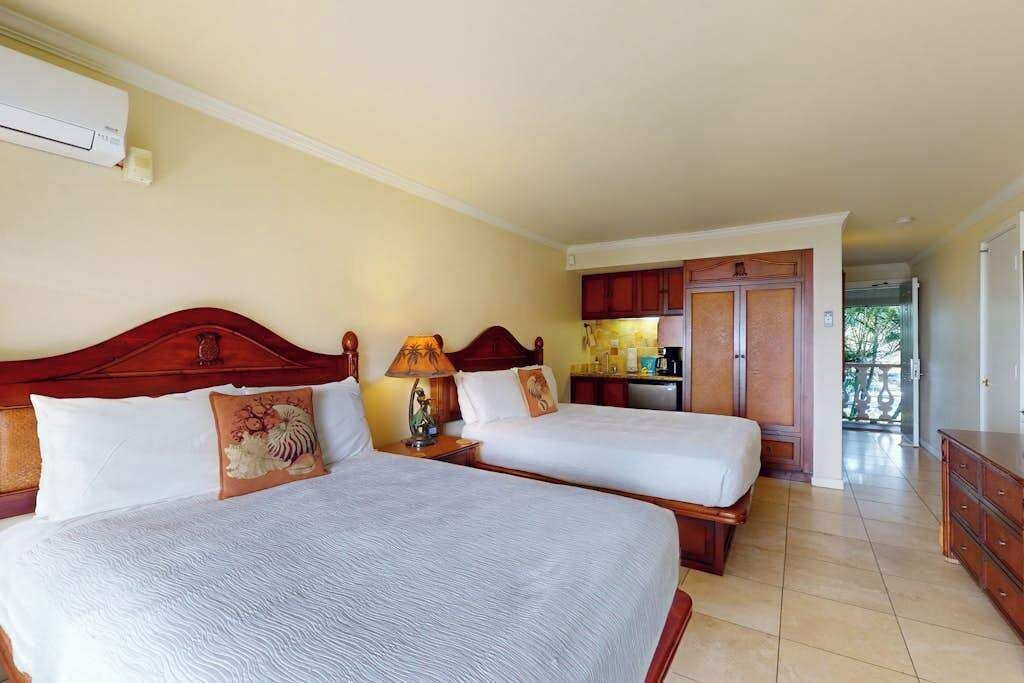 Una habitación de hotel con dos camas, un kitchenette y vistas al exterior.