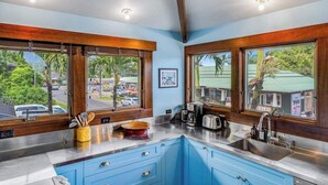 A kitchen with blue cabinets, a stainless steel countertop, and wooden window frames. - NEW Fall $ale Walk to Hanalei Bay from a Waterfall View Home TVNC#5120 (Hanalei)