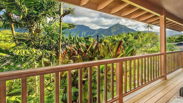 A wooden balcony with a view of lush tropical vegetation and mountains. - NEW Fall $ale Walk to Hanalei Bay from a Waterfall View Home TVNC#5120 (Hanalei)