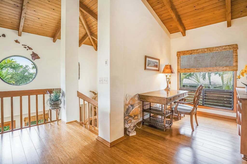 Une pièce au plancher de bois, comprenant une table à manger, des chaises, une fenêtre donnant sur un beau paysage et un élément décoratif circulaire sur le mur.