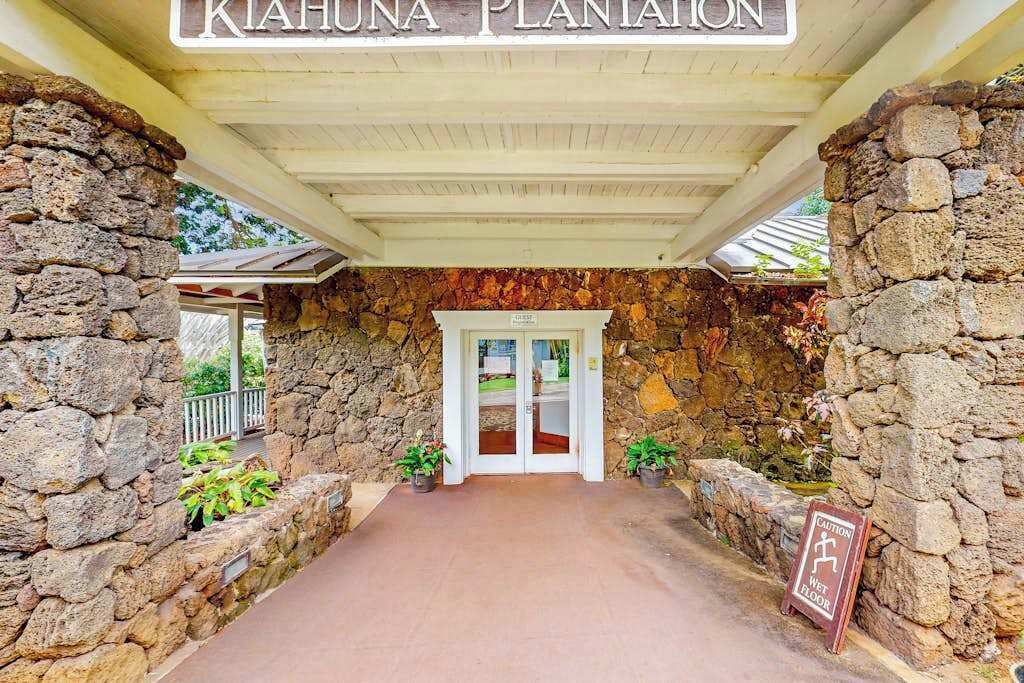 A stone entrance with a sign reading 'KIAHUNA PLANATION.'