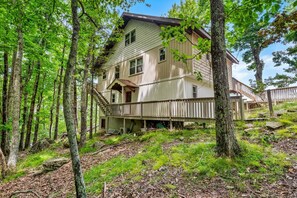 A two-story wooden house surrounded by a forest. - Beech on The Rocks | pet friendly, club access, mtn views (Banner Elk)