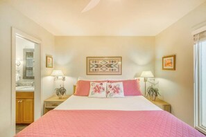 A bedroom with a bed, two bedside tables, a nightstand, a mirror, and a window. - Maualoha Condo Villa at Poipu's Brennecke's Beach with Pool/Spa, Shops, Dining (Poipu)